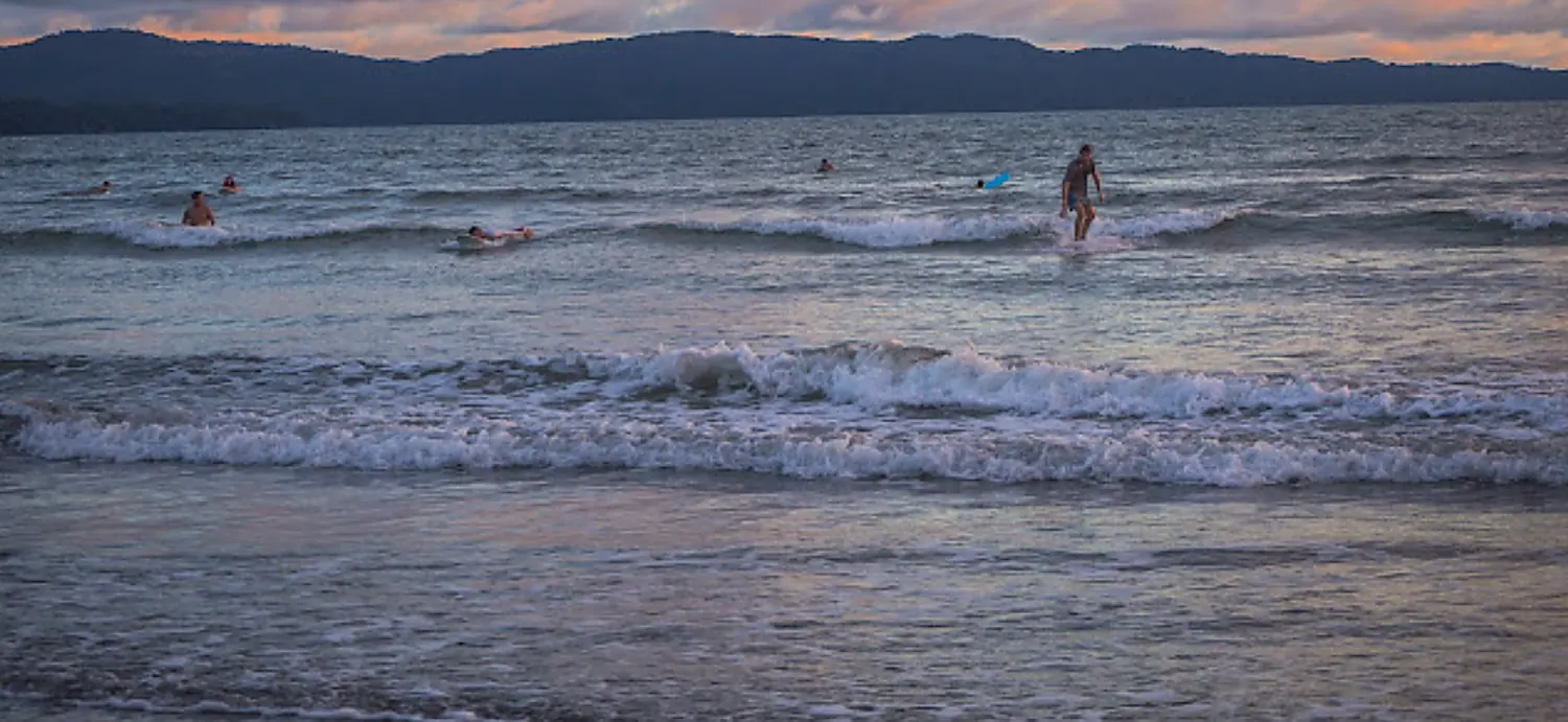 Beginner surf lesson at Playa Estero, Santa Catalina: a student standing on the board